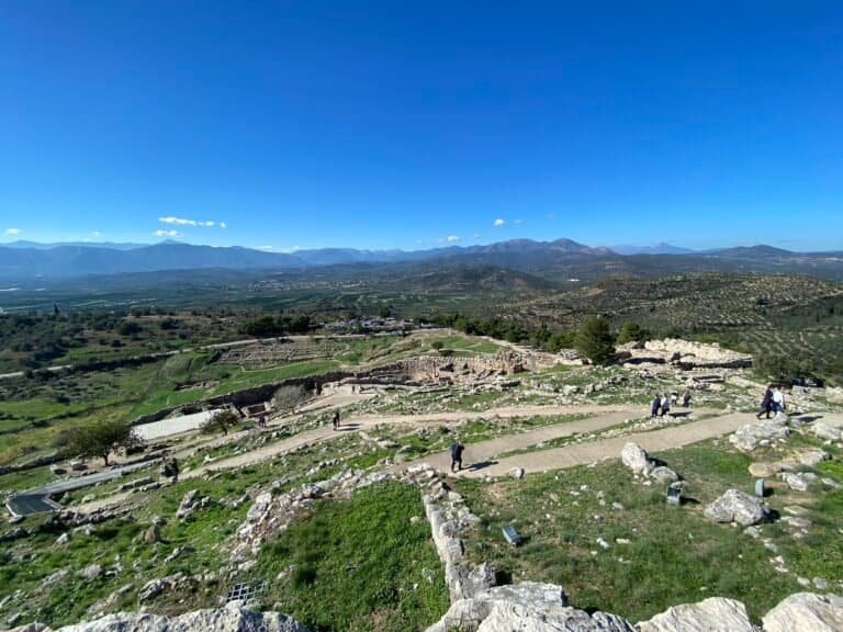Ancient ruins and archaeological site with visitors exploring the historic landscape.