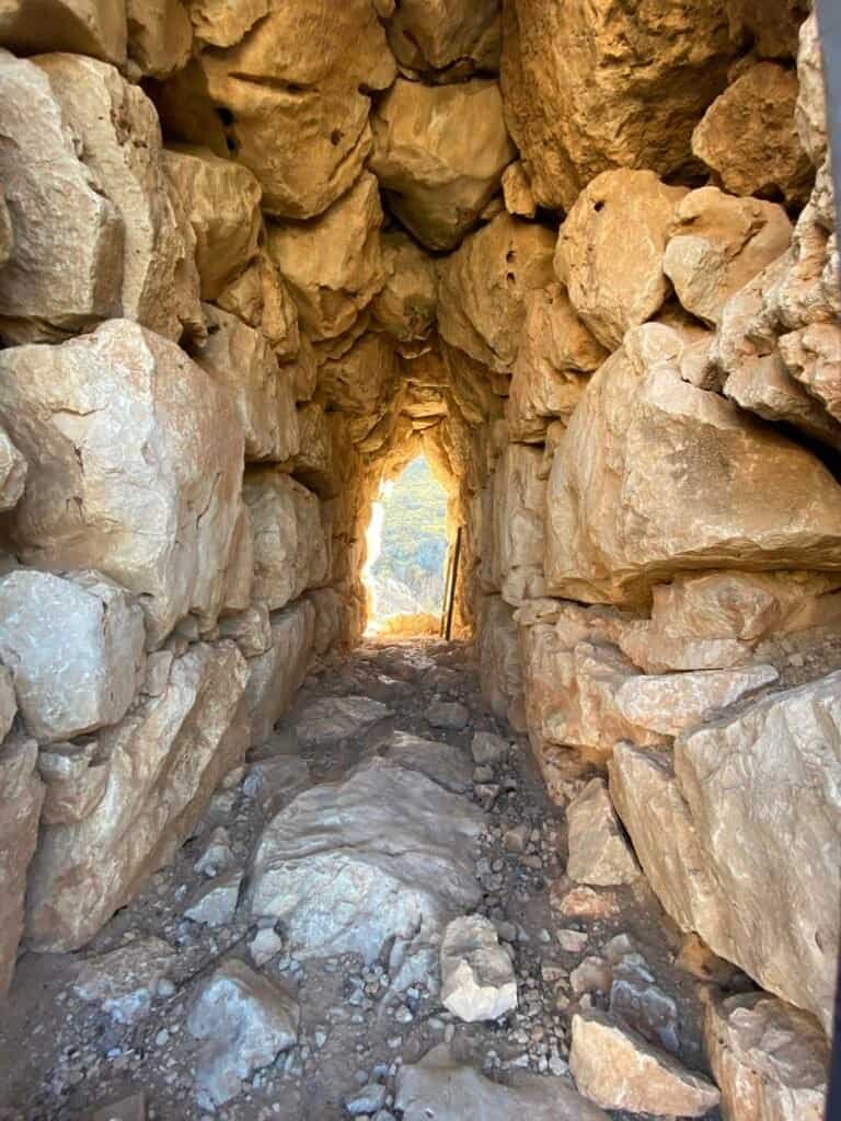 Narrow stone passageway with large rocks at Odyssey Academy.