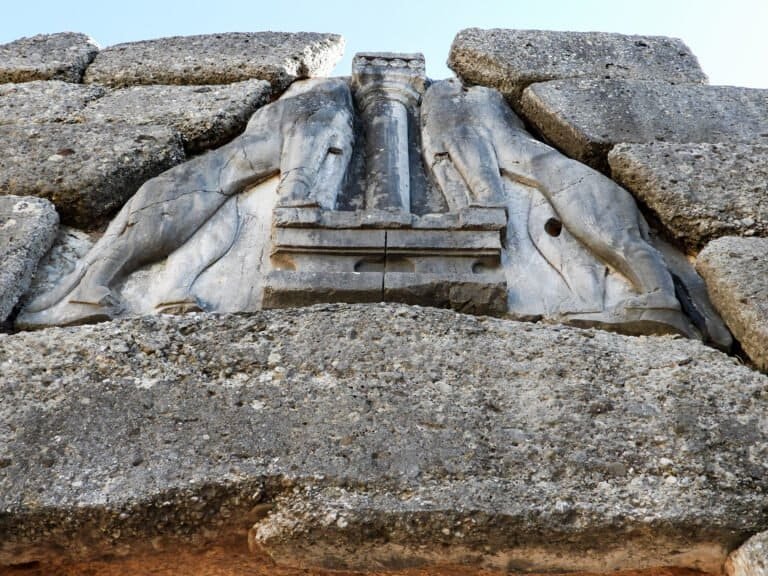 Close-up of ancient Greek stone architectural fragment with detailed carvings.