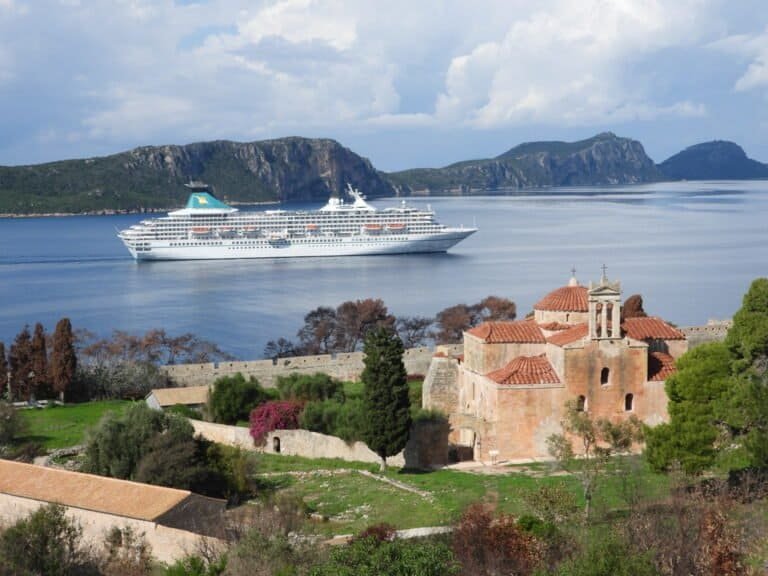 Odyssey Academy scenic coastal view with a cruise ship and historic church.