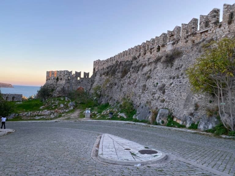 Ancient fortress walls overlooking the sea at sunset, showcasing historical architecture and scenic.