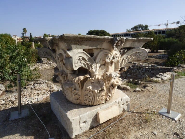 Ancient Corinthian column capital displayed at Odyssey Academy, showcasing classical Greek architect.