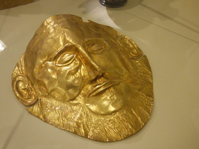 Gold funerary mask of an Egyptian pharaoh, showcasing intricate craftsmanship.