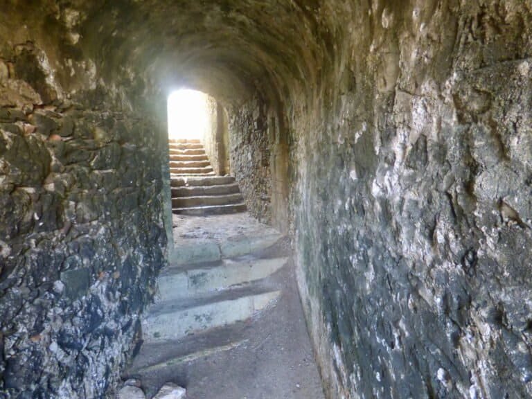 Stone tunnel with steps leading to light at Odyssey Academy.