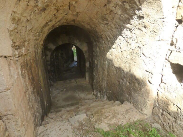Ancient stone tunnel with arched entrance at Odyssey Academy, showcasing historical architecture and.