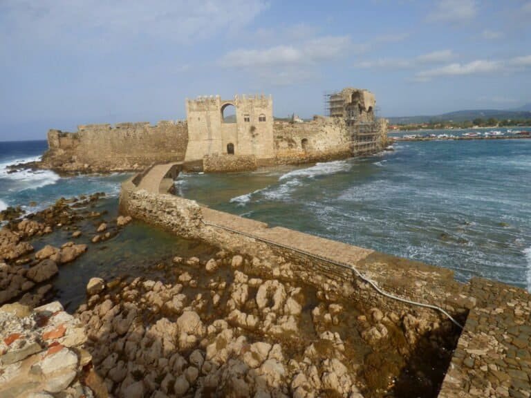 Historic coastal fortress with stone walls and towers by the sea.