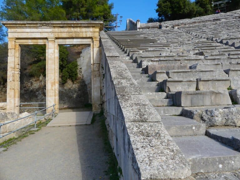 Historic Greek theatre ruins with stone steps and classical entrance.