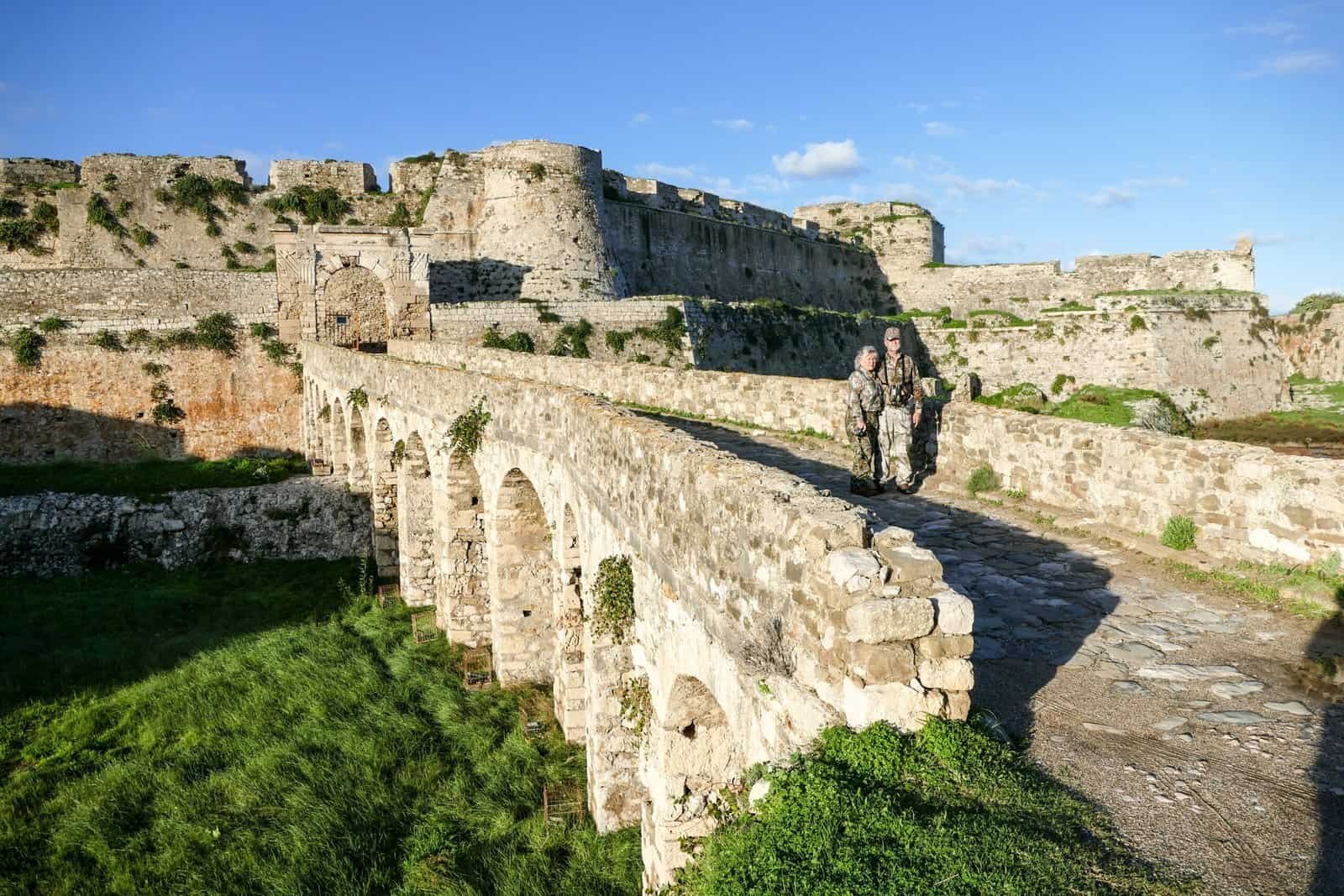 Historic fortress ruins with stone walls and arches, sunny sky backdrop.