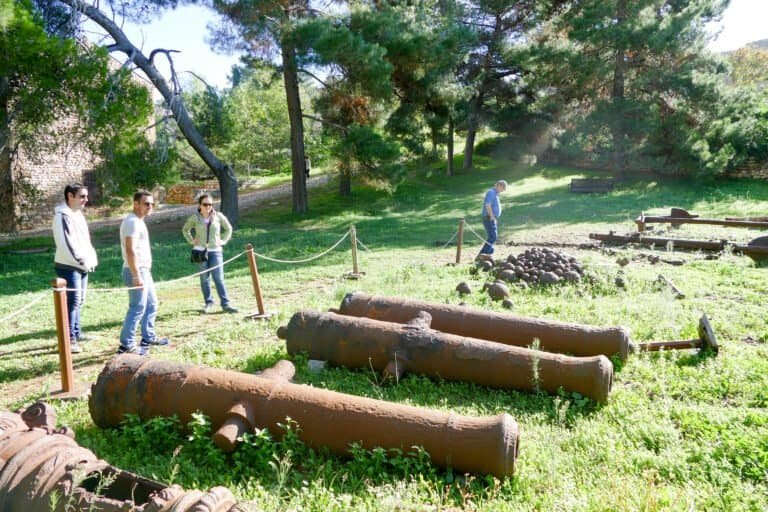 Visitors exploring historic cannons at Odyssey Academy outdoor site.