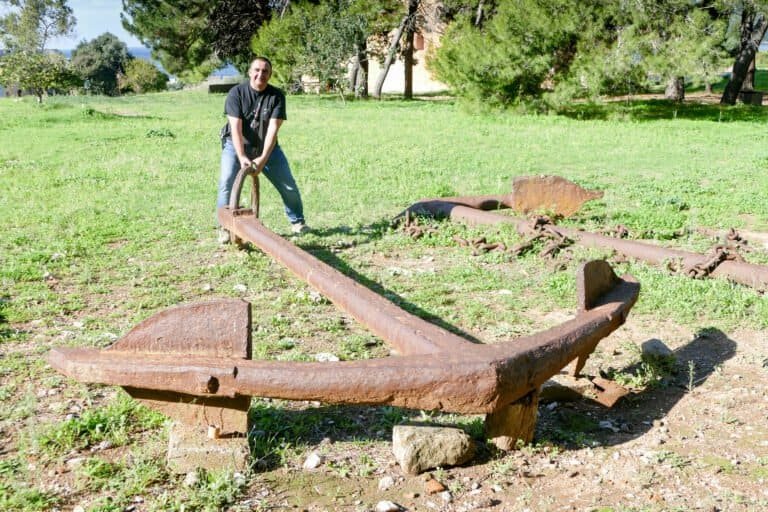Ancient boat remains displayed outdoors at Odyssey Academy, highlighting historical maritime artifac.