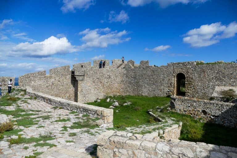 Ancient stone fortress with blue sky and clouds, archaeological site.