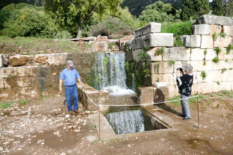 Restoring an ancient water mill with two people working on the site.
