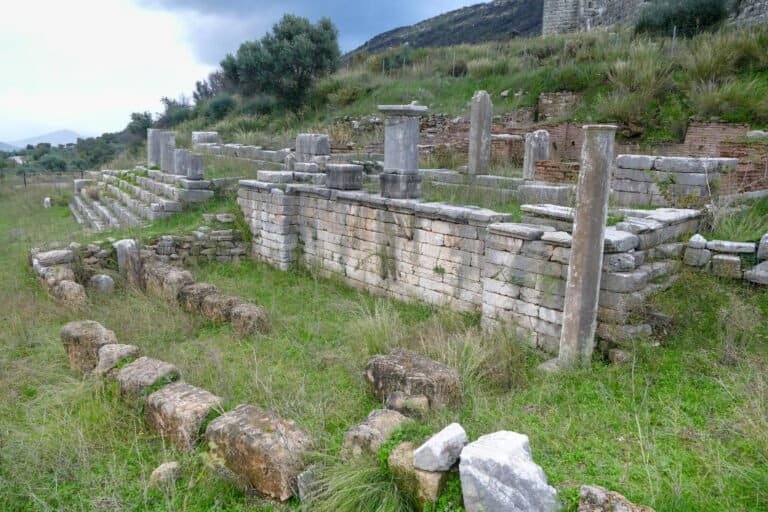 Ancient ruins with stone columns and steps at Odyssey Academy site.