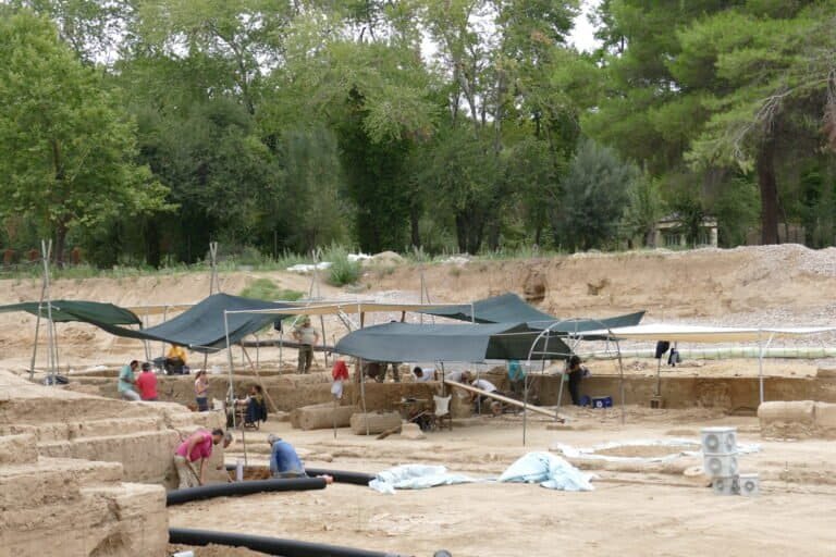 Archaeological excavation site with students and researchers working.