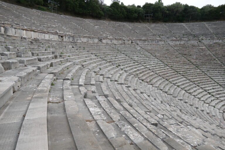 Ancient Roman amphitheater with stone seating and curved architecture.
