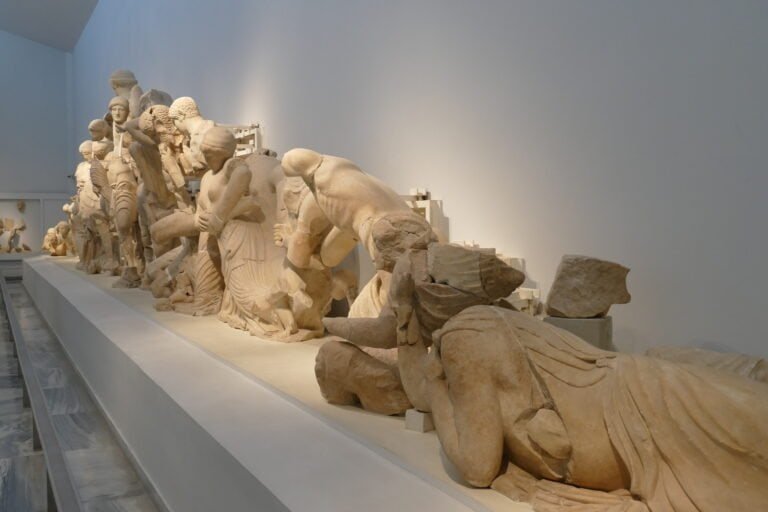Ancient Greek sculptures displayed in a museum exhibit, showcasing classical art and historical craf.
