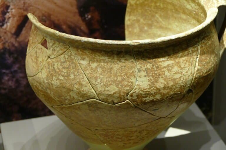 Ancient pottery vessel with visible cracks and weathered surface.